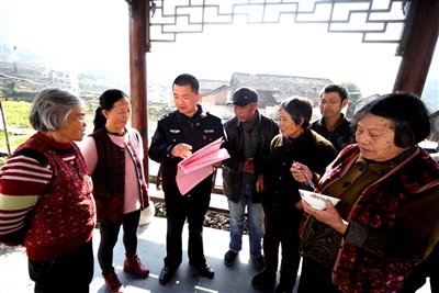 12月8日,歙县公安局王村派出所所长胡飞飞(左三)在石门乡石门村给