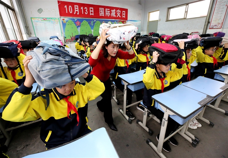 10月13日,山东省枣庄市鑫昌路小学的老师带领学生模拟演练地震逃生.